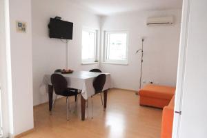 uma sala de jantar com uma mesa e cadeiras e uma televisão em Apartman AVA, 2+3, 250m od plaže em Novi Vinodolski