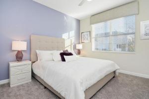 a bedroom with a white bed and a window at Wonderful Villas 18 Minutes away from Disney! in Kissimmee