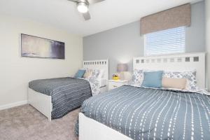 a bedroom with two beds and a window at Wonderful Villas 18 Minutes away from Disney! in Kissimmee