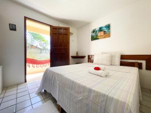 a bedroom with a white bed with a towel on it at Pousada Lua Cheia in Japaratinga