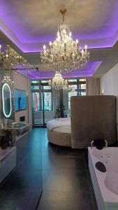 a large bedroom with a large bed and a chandelier at AGORA Tournai - Wellness Suites in Tournai