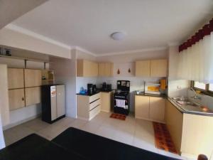 a kitchen with a black refrigerator and white cabinets at FH apartments opposite culture mambo in Nakuru