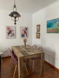 una sala da pranzo con tavolo e sedie in legno di Ría de Huelva a Huelva