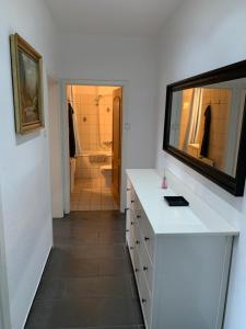 La salle de bains est pourvue d'un comptoir blanc et d'un miroir. dans l'établissement Easy travel - apartment in Krefeld Zentrum, à Krefeld