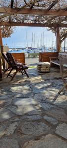 een patio met 2 stoelen, een bank en boten bij Casa CapiCorsu in Rogliano