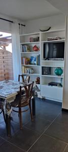 een woonkamer met een tafel en een televisie bij Casa CapiCorsu in Rogliano