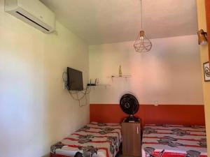 ベベリベにあるSítio RoThaSのベッド2台とテレビが備わる客室です。