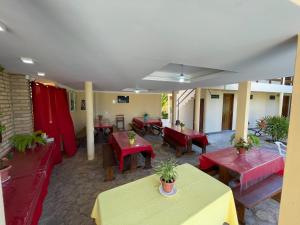 um restaurante com mesas e bancos e mesas vermelhas em Pousada Lua Cheia em Japaratinga