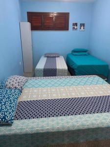 3 camas en una habitación con paredes azules en Sítio RoThaS, en Beberibe