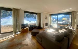 sala de estar con sofá y ventanas grandes en Schooren des Alpes Luxury Apartments, en Kappl