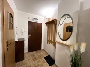 a hallway with a bathroom with a mirror and a door at Apartament Orange Piastowska in Ostróda +5 photos