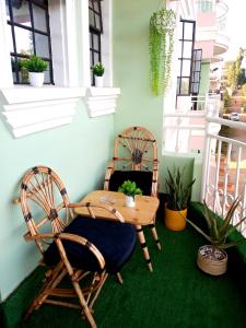 a patio with two chairs and a table on a balcony at T Tree Paradise Apartments Embu in Embu