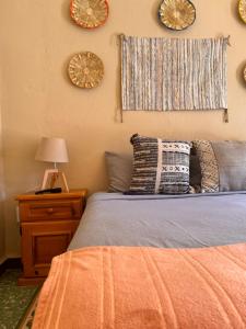 a bedroom with a bed and clocks on the wall at Bokatrip El Llano in Oaxaca City