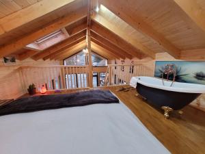 a large room with a bath tub and a bed at Cucu Zen Cazare Cabane Pensiuni Bucovina 