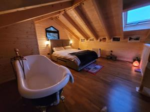 a bedroom with a bed and a bath tub in a room at Cazare Cabana Pensiuni Vatra Dornei Bucovina cu Ciubar in Iacobeni
