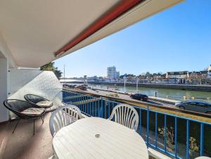 einen Balkon mit einem Tisch und Stühlen sowie Blick auf das Wasser in der Unterkunft Superbe appartement et vue - 4 pers - Parking in La Baule