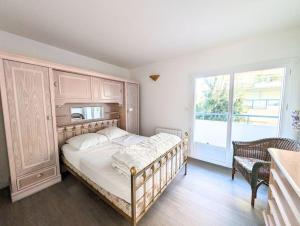 ein Schlafzimmer mit einem Bett und einem großen Fenster in der Unterkunft Superbe appartement et vue - 4 pers - Parking in La Baule