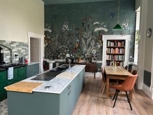 uma cozinha com armários verdes e uma pintura na parede em Coopershill House em Riverstown