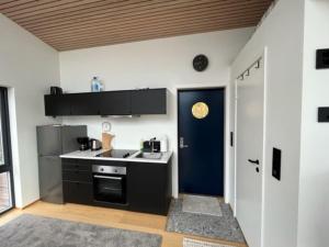 a kitchen with black appliances and a blue door at Efjord - magic nature in Ballangen