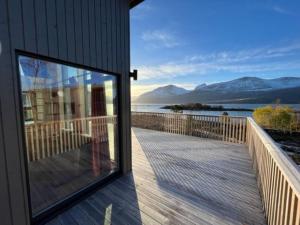 a balcony with a view of the water and mountains at Efjord - magic nature in Ballangen