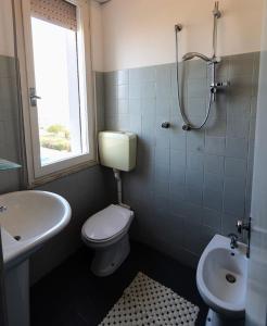 e bagno con servizi igienici, lavandino e doccia. di Hotel Atlas a Cesenatico