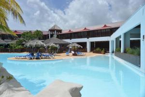 a large swimming pool with chairs and umbrellas at The Ohana Studio in Saint-François