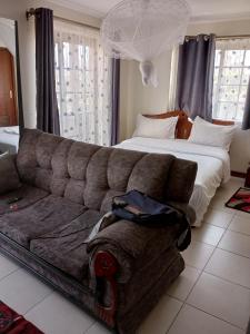 a living room with a couch and a bed at Mvuli suites studio in Nairobi