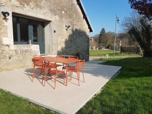 tavolo e sedie rossi di fronte a un edificio di Le Cottage a Sorans-lès-Breurey