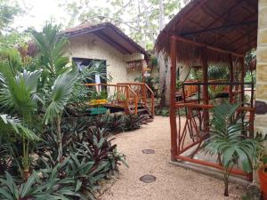 un jardin avec un bâtiment doté d'un kiosque dans l'établissement Aldea Kinich, à Tulum