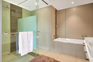 a bathroom with a shower and a sink and a tub at Executive 3 bed apartment with balcony & Executive 2 bed apartment in Sandton in Johannesburg