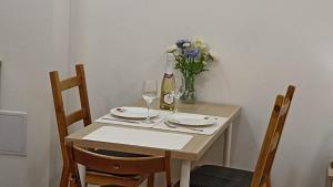 a table with two chairs and a vase of flowers at M&M Apartment Budapest House in Budapest