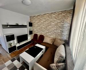 sala de estar con sofá y pared de ladrillo en Villa Eti en Dospat