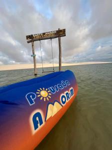 - un bateau à pédales orange et bleu dans l'eau dans l'établissement POUSADA AMORIM, à Santo Amaro