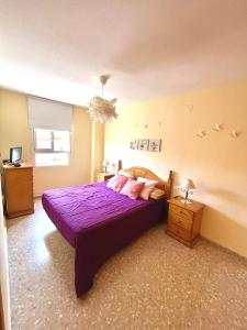 a bedroom with a purple bed with pink pillows at Apartamento en la Playa Canet, muy cerca de Valencia in Canet de Berenguer
