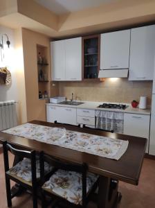 a kitchen with white cabinets and a wooden table at Ruggiero "Casa Vacanze" in Vallo della Lucania