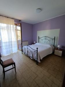 - une chambre avec un lit, une chaise et une fenêtre dans l'établissement La Finestra Sui Monti, à Arcevia