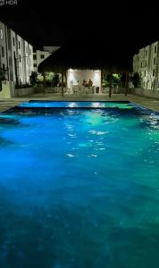 - une grande piscine d'eau bleue la nuit dans l'établissement Departamento eco-chic a 10 min del centro, à Tulum