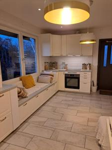 a kitchen with white cabinets and a large window at Lägenhet på Rosenlund in Jönköping