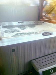 a jacuzzi tub in a room with a window at Whiskers and Woods Shepherd Hut 