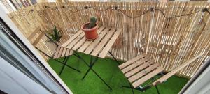 a potted plant sitting on a bench next to two chairs at Apartamento en el centro de Elche con terraza La Alborada in Elche +28 photos