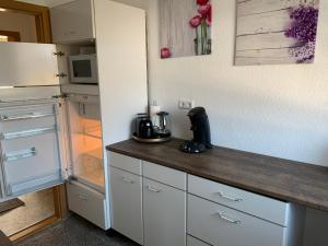 cocina con encimera y nevera en FeWo an der Weser, en Nordenham