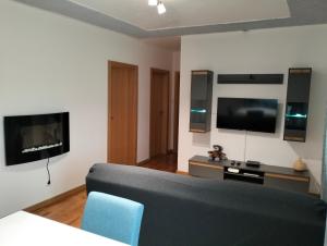 salon z kanapą i telewizorem z płaskim ekranem w obiekcie CASA NOVA MONTALEGRE w mieście Montalegre