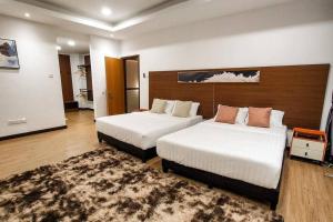 a hotel room with two beds and a rug at Zinnia Residence in Tanah Rata