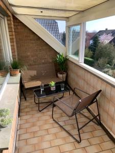 eine Terrasse mit einem Tisch, einem Stuhl und einer Bank in der Unterkunft Ferienwohnung Wanderlust in Bad Rothenfelde