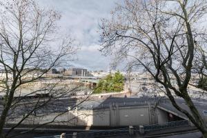 Blick auf eine Stadt mit Bäumen und einem Zug in der Unterkunft Spacieux 2 Chambres Appart Boulogne-Quai in Boulogne-Billancourt