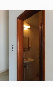 ein Bad mit einem Waschbecken und einem Spiegel in der Unterkunft Résidence cœur de Marie in Abomey-Calavi