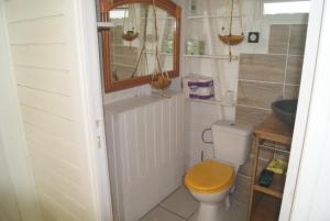 La salle de bains est pourvue de toilettes et d'un siège en bois. dans l'établissement Kaz à Skanky, au Gosier
