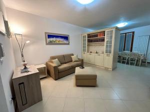 ein Wohnzimmer mit einem Sofa und einem Tisch in der Unterkunft Appartamento A Casa Nostra in Rivotorto