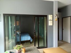 a room with a room with a bed and a glass door at Happy home Suratthani 152/57 in Amphoe Koksamui