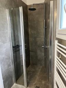 a shower with a glass door in a bathroom at Ariadni's home - Einfamilienhaus mit Meerblick in Nea Stira